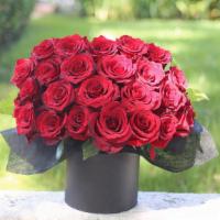 Scarlett  · Red roses with some greenery in a box.