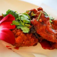 Tamarind Wings · Five crispy wings cooked in a tangy tamarind sauce with fried green onions and fresh cilantr...