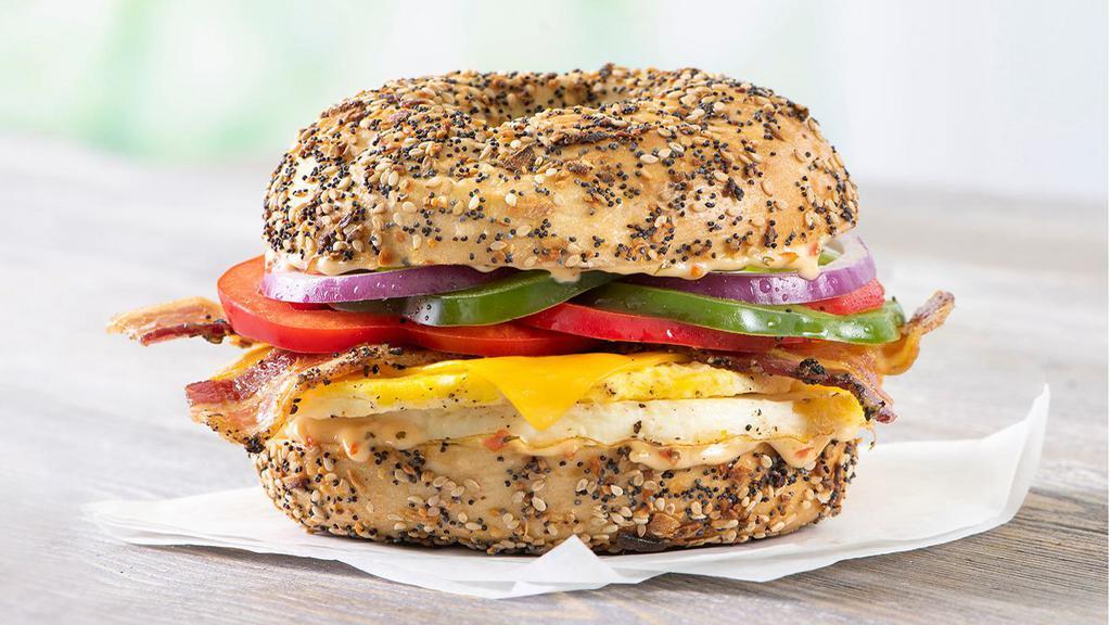 Western · Fresh-cracked egg, bacon, cheddar cheese, chipotle sauce, and a mix of green peppers, red peppers, and red onions on an everything bagel.