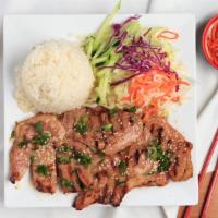 Com Suon · Grilled teriyaki pork chop with steamed rice served with fresh salad & fish sauce.