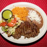 Carne Asada · Marinated beef cooked to perfection. Comes with rice, beans, guacamole and salad.