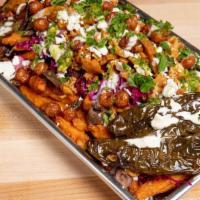 Street Style Sweet Potato Fries · Sweet potato fries loaded with eggplant, fried jalapenos, chickpea croutons, kale salad, pic...
