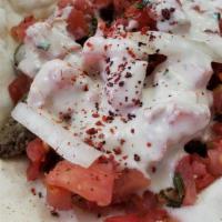 Beef Shawarma Taco · Homemade fresh mini bread topped with beef shawarma, parsley, onions, tomatoes, cilantro & t...