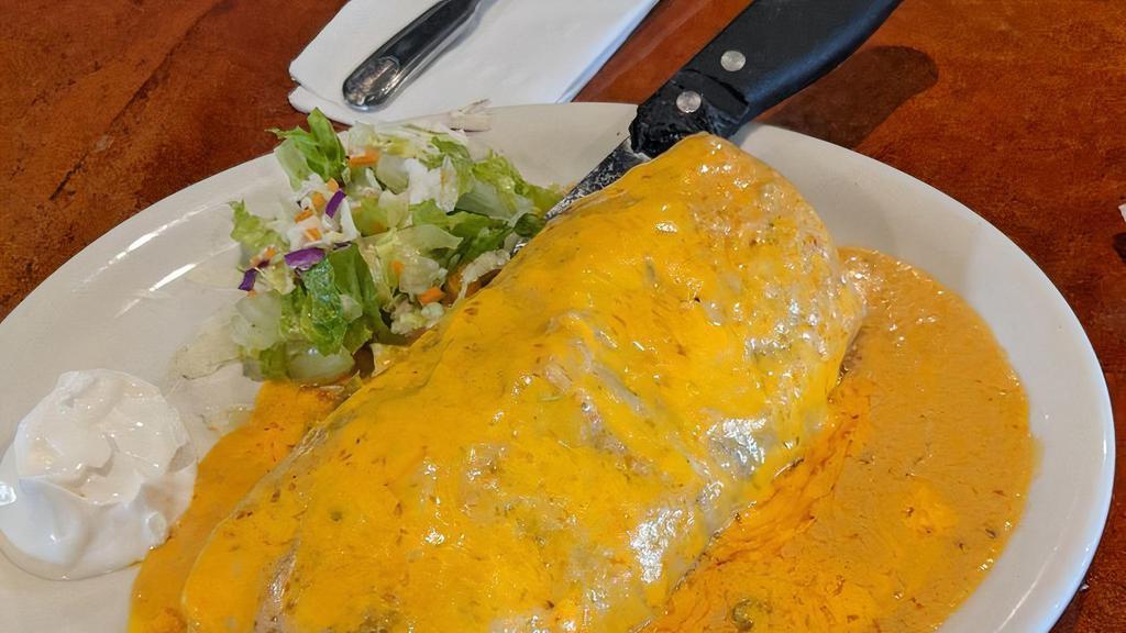 Surf Turf Burrito · House specialty. Steak or chicken, filled with shrimp, rice, beans and cheese. Topped with a house specialty. Steak or chicken, filled with shrimp, rice, beans and cheese. Topped with our special sauce and sour cream on the side.