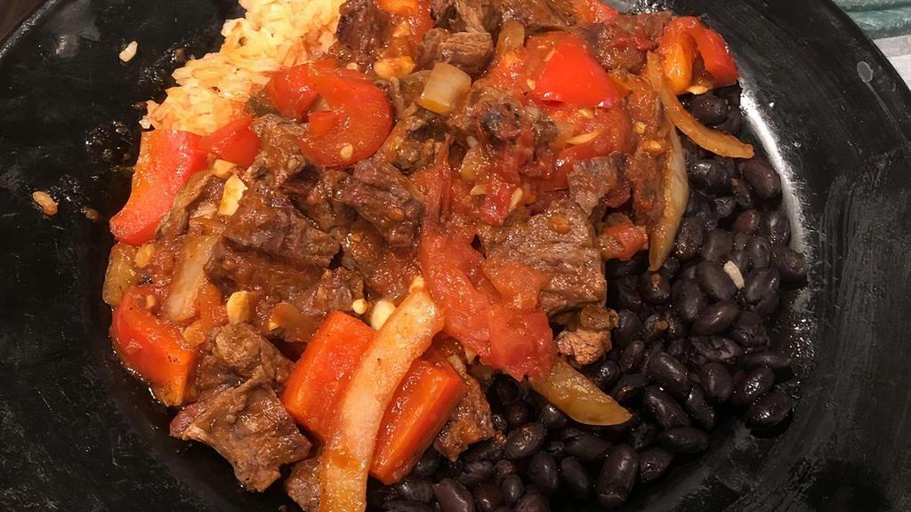 Steak Ranchero · Grilled sirloin steak sautéed with onion, bell peppers, tomatoes, garlic and ranchera salsa over rice and black beans. Served with rice, beans and tortillas.