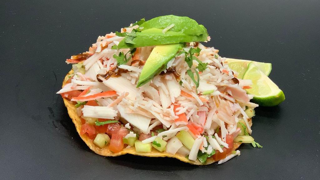 Tostada De Jaiba (Imitacion)/Imitation Crab Tostada · Jaiba (imitacion) con cilantro, tomate, cebolla y pepino  en cuadros, marinada en jugo especial de la casa, aguacate y chile.
Imitation crab, cilantro, tomato, onion and cucumber. Marinated in a special house juice, avocado and chili.
