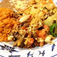 Machaca · Eggs scrambled with carne asada, onions, tomatoes, jalapenos served with rice & beans on the...