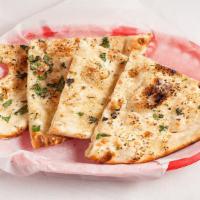 Garlic Naan · Flat leavened bread with finely chopped garlic baked onto the wall lining of the tandoori ov...