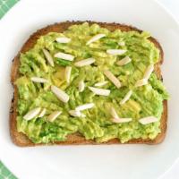Avocado Toast Crunch · Avocado toast topped with almonds and olive oil.