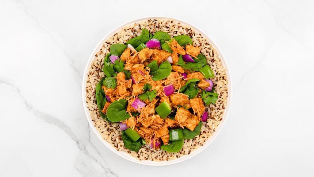 Thai Buddha Chicken · Quinoa and Brown Rice topped with chicken, onions and bell peppers grilled in Thai and Schug sauce and; carrots, cilantro and spinach.