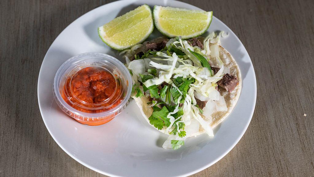 Lengua Taco · Beef tongue taco top with cabbage, onion, and cilantro.