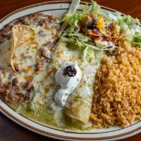 Enchiladas Suizas · Two corn tortillas filled with cheese or chicken, topped with green tomatillo sauce and sour...