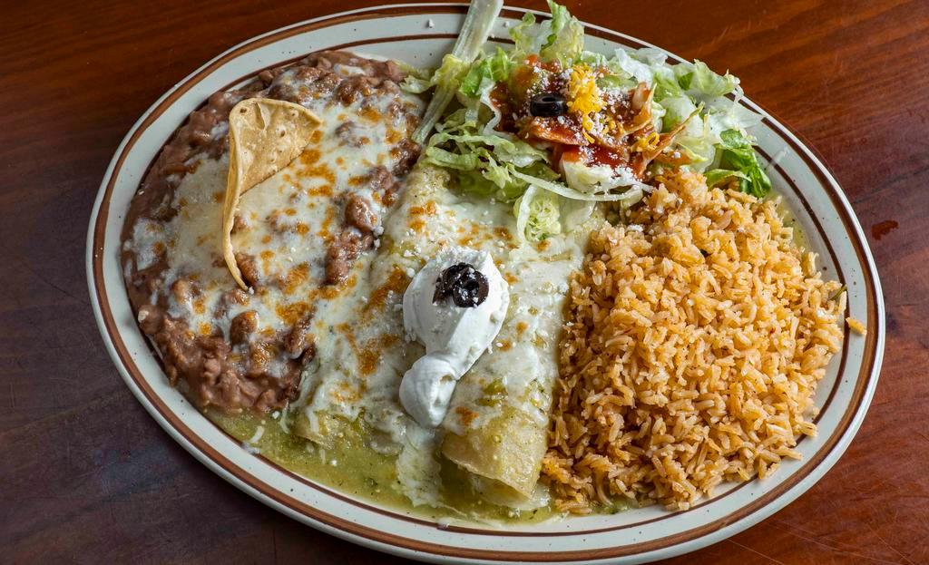 Enchiladas Suizas · Two corn tortillas filled with cheese or chicken, topped with green tomatillo sauce and sour cream. Served with rice and beans.