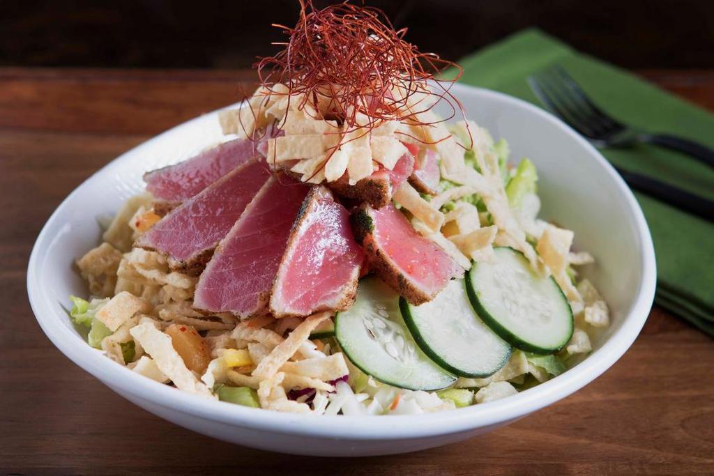 Ahi & Avocado Salad · Tender Ahi drizzled lightly with a pineapple and chili salsa, accompanied with fresh avocado on a bed of Asian slaw, crisp greens with cucumbers, almonds, wontons and served with toasted sesame dressing.