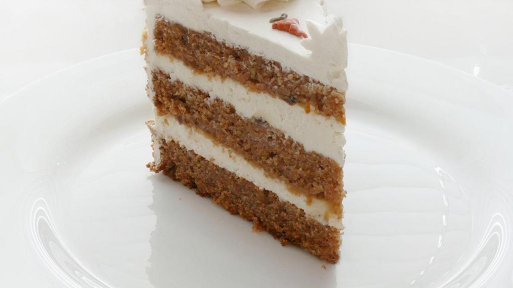 Sliced Carrot Cake · Alternating layers of carrot cake spiced with cinnamon, chopped walnuts, and pineapple, covered with a smooth cream cheese topping and sprinkled with crushed walnuts.
