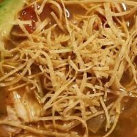 Tortilla Soup · Vegetable soup with shredded chicken, cheese, tortilla strips, and fresh avocado slices.