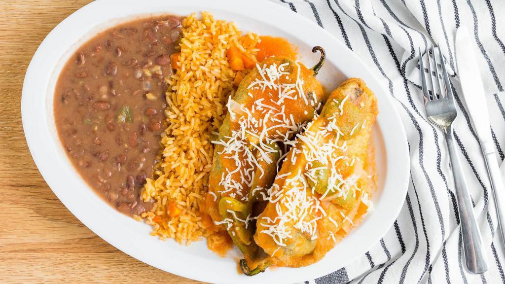 Chile Rellenos · 2 bell peppers grilled, deep-fried, stuffed with melted cheese, and smothered with mild tomato sauce. It comes with rice and beans 4 handmade corn tortillas.