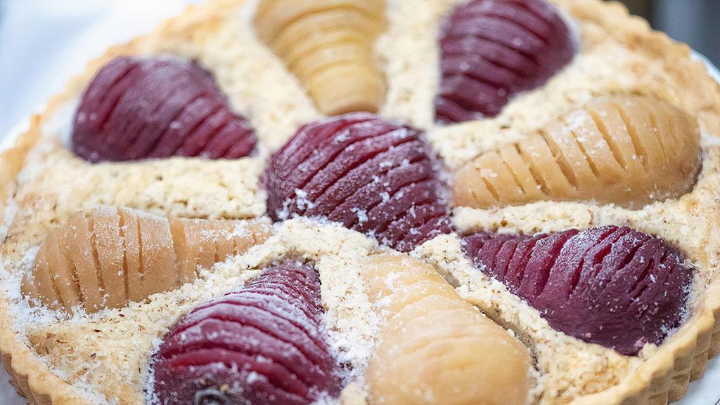 Whole Pear Almond Tart · Fresh pears poached in red and white wine alternate for a beautiful design on an almond filling in an all butter pastry.