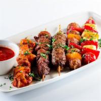 Beef Kabob Plate · Marinated beef kebobs (2 pcs), choice of three sides, grilled tomatoes, and warm pita bread.