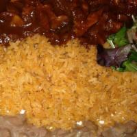 Camarones A La Diabla · Spicy red sauce, large shrimp, mushrooms, onions with rice, beans and garnish.