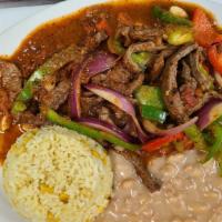 Bistec Ranchero · pimiento rojo y verde, cebolla con salsa ranchera hecha en casa, arroz, frijol y tortillas /...