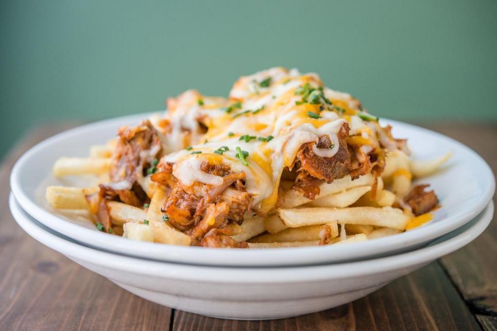 Piggy Cheese Fries · Crispy fries loaded served under slow roasted BBQ pork covered in cheese.