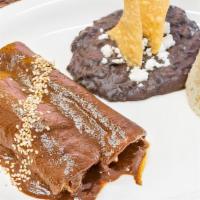 Enchiladas De Mole · Two Mole Poblano Enchiladas with your choice of Chicken, Cheese, or Shredded Beef. Served wi...