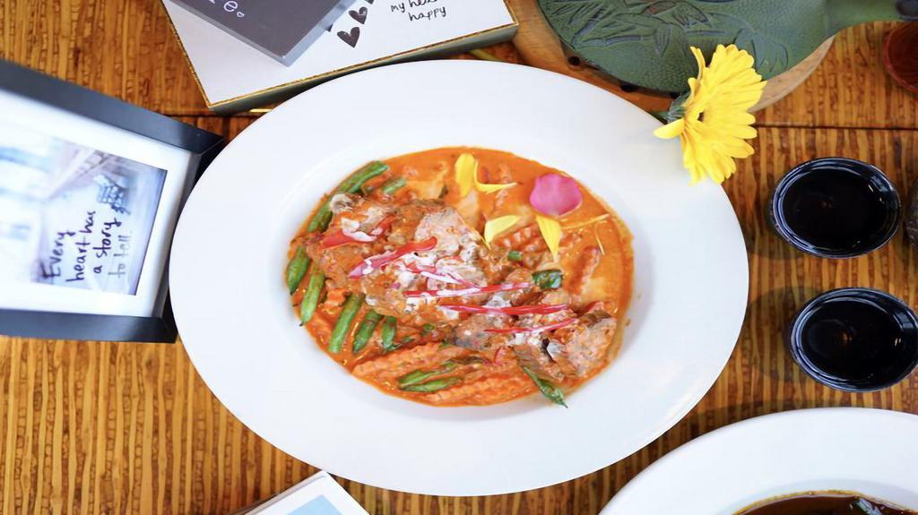 Panang Beef · Authentic Thai crimson-hued dish, combines bright lemongrass and sweet coconut milk to infuse braised beef with rich flavor. Served on the bed of steamed green beans and carrots, with your choice of rice on the side.