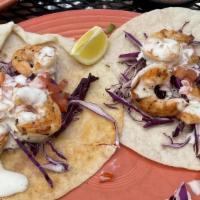 Tacos De Camarones · Three flour tortillas filled with shrimp, topped with cabbage and vientos sauce; served with...