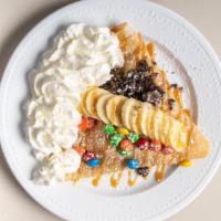 Banana And Sweets · Banana, M&M's, Oreos, caramel powder sugar and whipped cream.