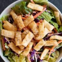 Asian Crispy Wonton Salad · Romaine lettuce, shredded purple cabbage, carrots, and crispy wontons, topped with house-mad...