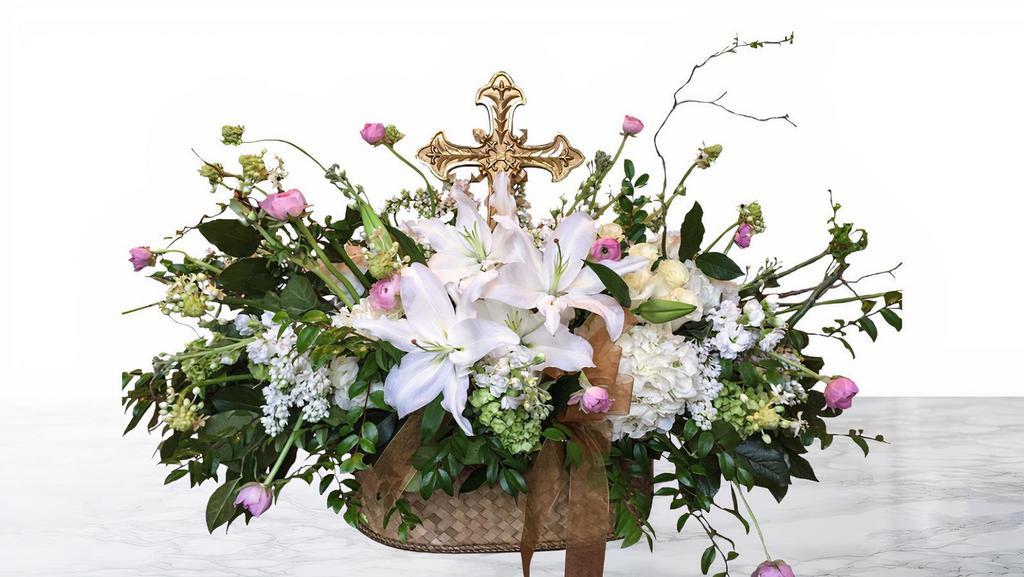 Spiritual Serenity · A Golden Cross is the centerpiece of this lush arrangement.  Filled with hydrangea, stock, roses, seasonal greenery, tulips and ranunculus.  Available in feminine and masculine color palettes.