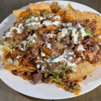 Super Nachos · Meat, refried beans, guacamole, nacho cheese, jack cheese and sour cream.
