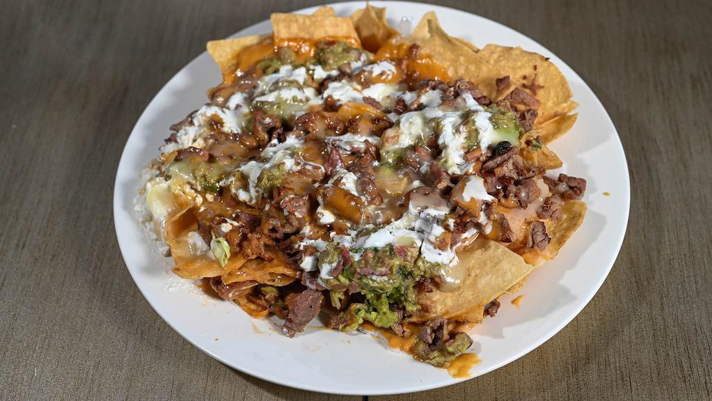 Super Nachos · Meat, refried beans, guacamole, nacho cheese, jack cheese and sour cream.