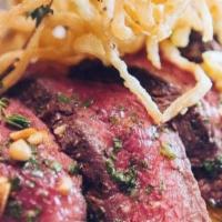 Grilled Herb Marinated Creekstone Flat Iron Steak · Smoked bacon, Tuscan potatoes, wilted spinach, crispy onion strings and pine nut-arugula chi...