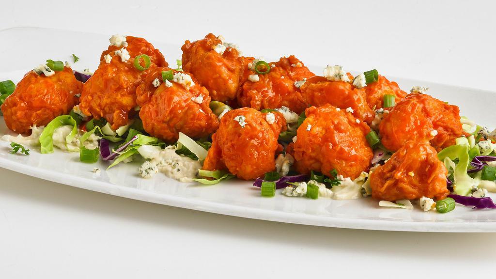 Buffalo Cauliflower · Lightly battered and fried cauliflower florets tossed in our buffalo sauce on a bed of bleu cheese dressing and crunchy cabbage. Topped with crumbled bleu cheese and freshly sliced scallions. (850 Cal)
