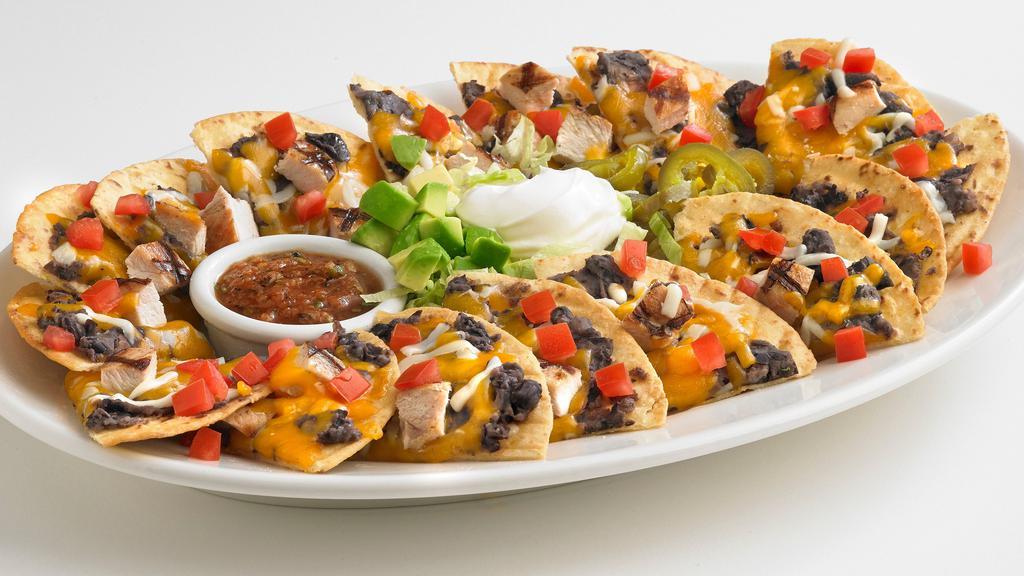 Boston'S Nachos · Our signature half flour, half corn tortilla chips, individually topped with cheddar and mozzarella cheeses, refried black beans, and tomatoes. Served with shredded lettuce, jalapeños, sour cream, avocado, and salsa.