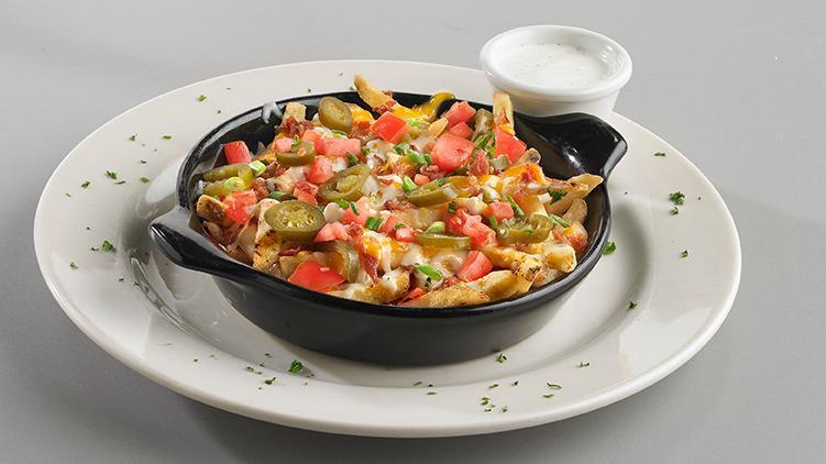 Loaded Cheese Fries · Fries smothered in our rich queso topped with fresh jalapeños, diced tomatoes, and bacon. Garnished with green onion and parsley.