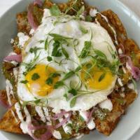 Chilaquiles · 2 sunny eggs, corn tortilla chips, Verde, lime crema, cotija cheese, salsa roja, and cilantro.