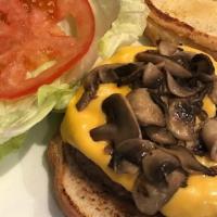 Mushroom & Onions Burger · Topped with sautéed mushrooms, grilled onions, lettuce, tomatoes, pickles and cheddar cheese.
