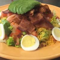Country Kitchen Salad · A crisp bed of greens topped with avocado, bacon, tomatoes, a hard-boiled egg and cheddar ch...