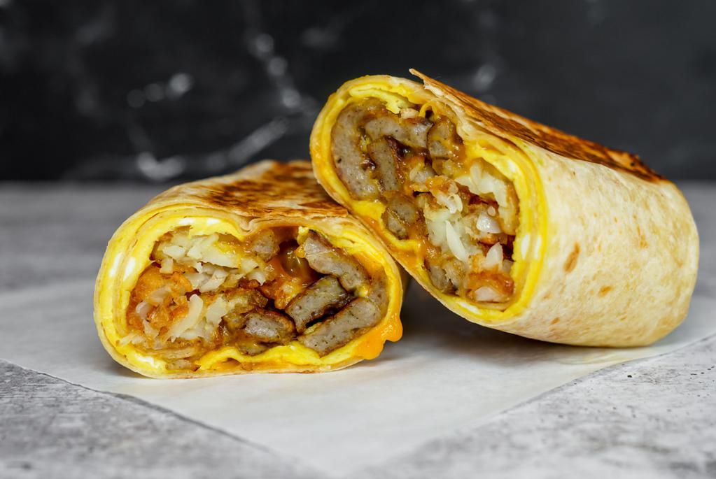 Impossible Sausage, Egg, And Cheddar Breakfast Burrito · Delicious vegetarian option for your savory breakfast burrito. 3 fresh cracked, cage-free scrambled eggs, melted Cheddar cheese, seared Impossible sausage patties, and crispy potato tots wrapped in a toasted 12” flour tortilla. Comes with avocado salsa verde side.