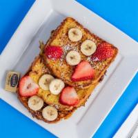 French Toast · Three full slices of French toast, served with strawberries and bananas on top.