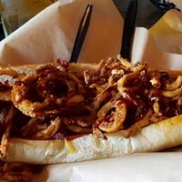 Western Dog · ¼ lb dog topped with applewood smoked bacon, house-made BBQ sauce & fried onion strings.