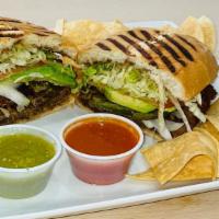 Torta De Milanes · Your Choice of Meat Topped with Pinto Beans, Mayo, Lettuce, Onion, Avocado, and Jalapeno. Me...