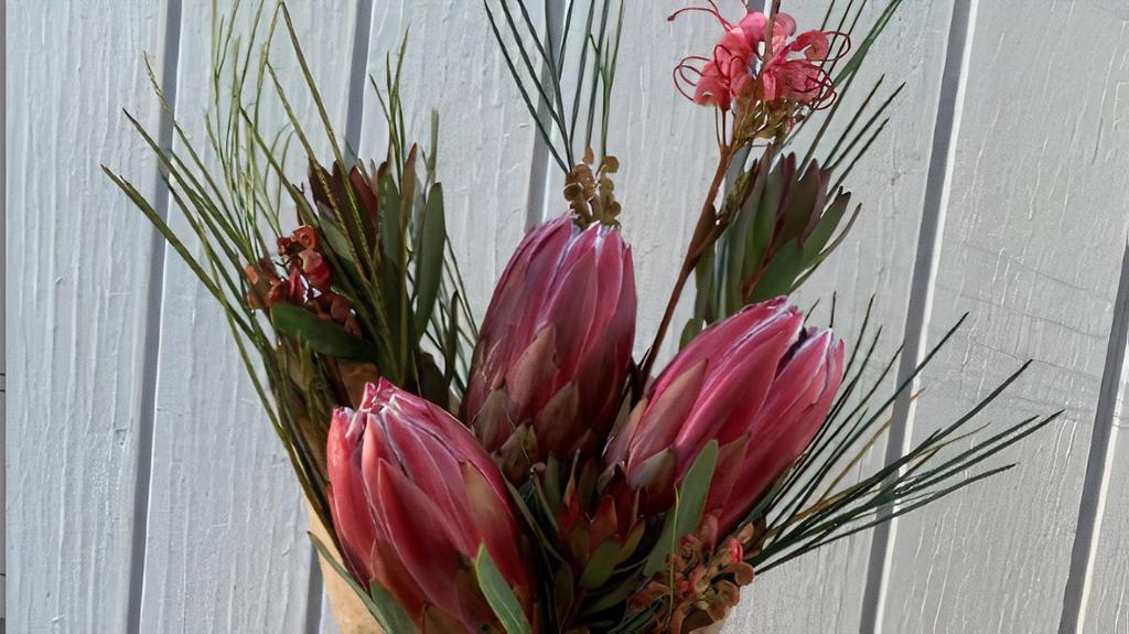 The Pheonix Of Flowers Bouquet · Have a  fresh picked Protea bouquet delivered to your door. This sweet little bouquet is the perfect pick me up is for any occasion. 

The Protea flower represent longevity, diversity, transformation, resilience, courage and individuality. Even when the land has been destroyed by fire, the seeds of these flowers remain with ability to birth new life from the ashes. A reminder to us, that even through the fires of life there is hope. Protea flowers are the ‘Phoenix of Flowers’ rising out of the ashes transforming adversity and destruction in to one of the most beautiful flowers in the world. 

Three fresh picked Protea flowers snuggling together alongside streams of Graviella, and Lucadendron.