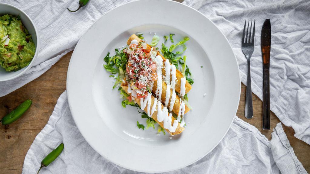 Taquitos · Three crispy rolled corn tortillas, filled with chicken and topped with lettuce, sour cream and pico de gallo.