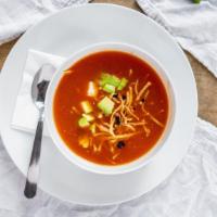 Tortilla Soup · Made with roasted tomatoes, chicken broth, and pasilla chile. Topped with diced avocado, que...