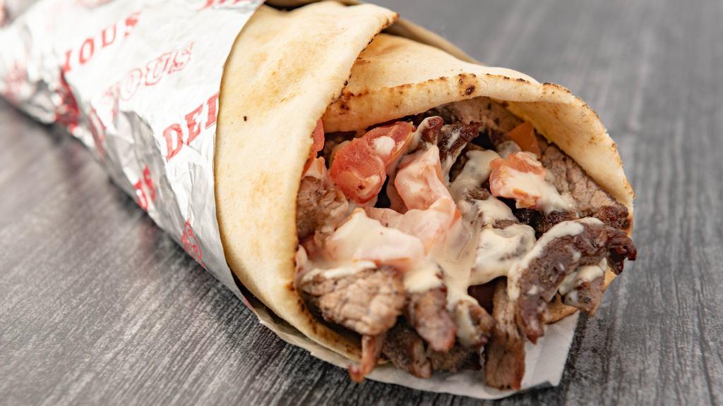 Beef Shawerma Pita · Seasoned Beef slowly grilled on our vertical grill, topped with Lettuce, Tomatoes, Onions and Tahini Sauce.