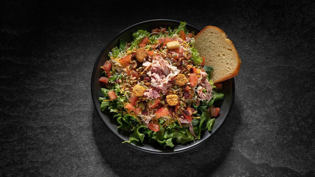 Chef  Salad   · Includes: Ham, Turkey, Cheese on Salad Greens with Tomatoes, Seasoned Croutons and Specialty Seed Topping.  Your choice of dressings and a slice of our specialty bread.